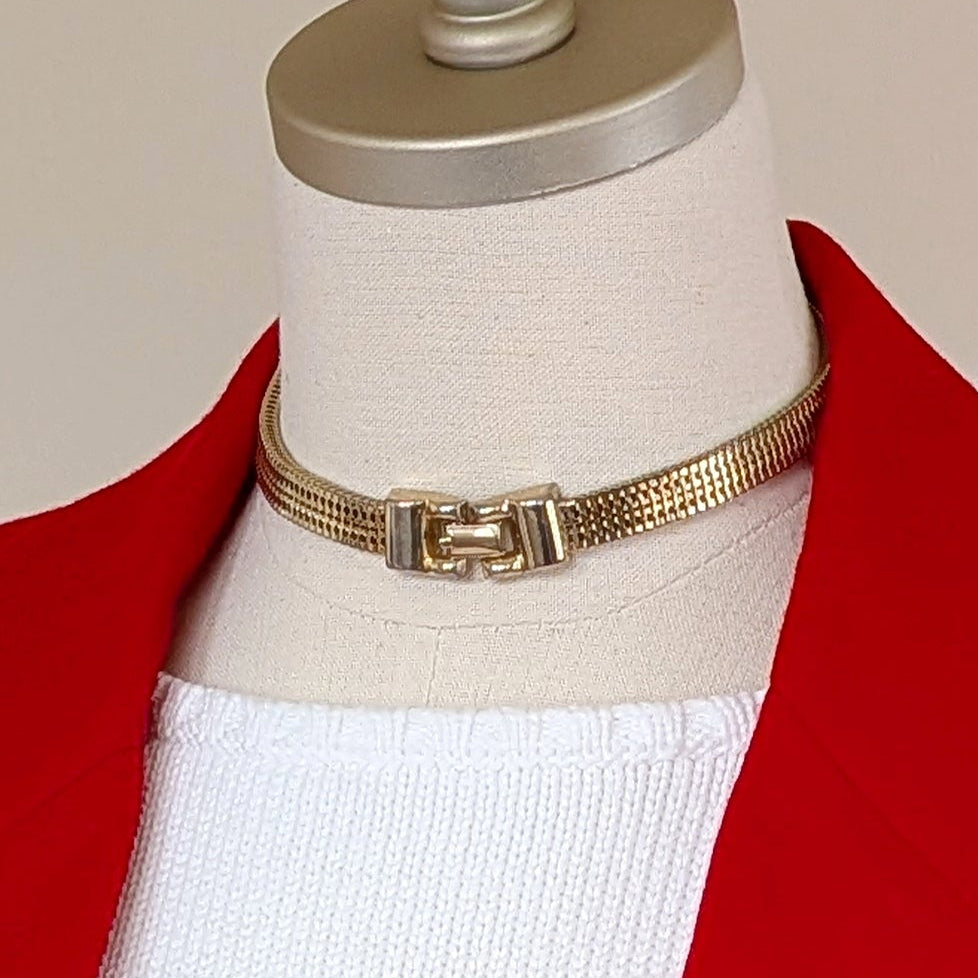 Red blazer with gold buttons on a mannequin against a plain background