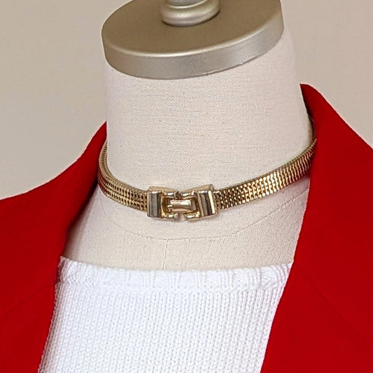 Red blazer with gold buttons on a mannequin against a plain background